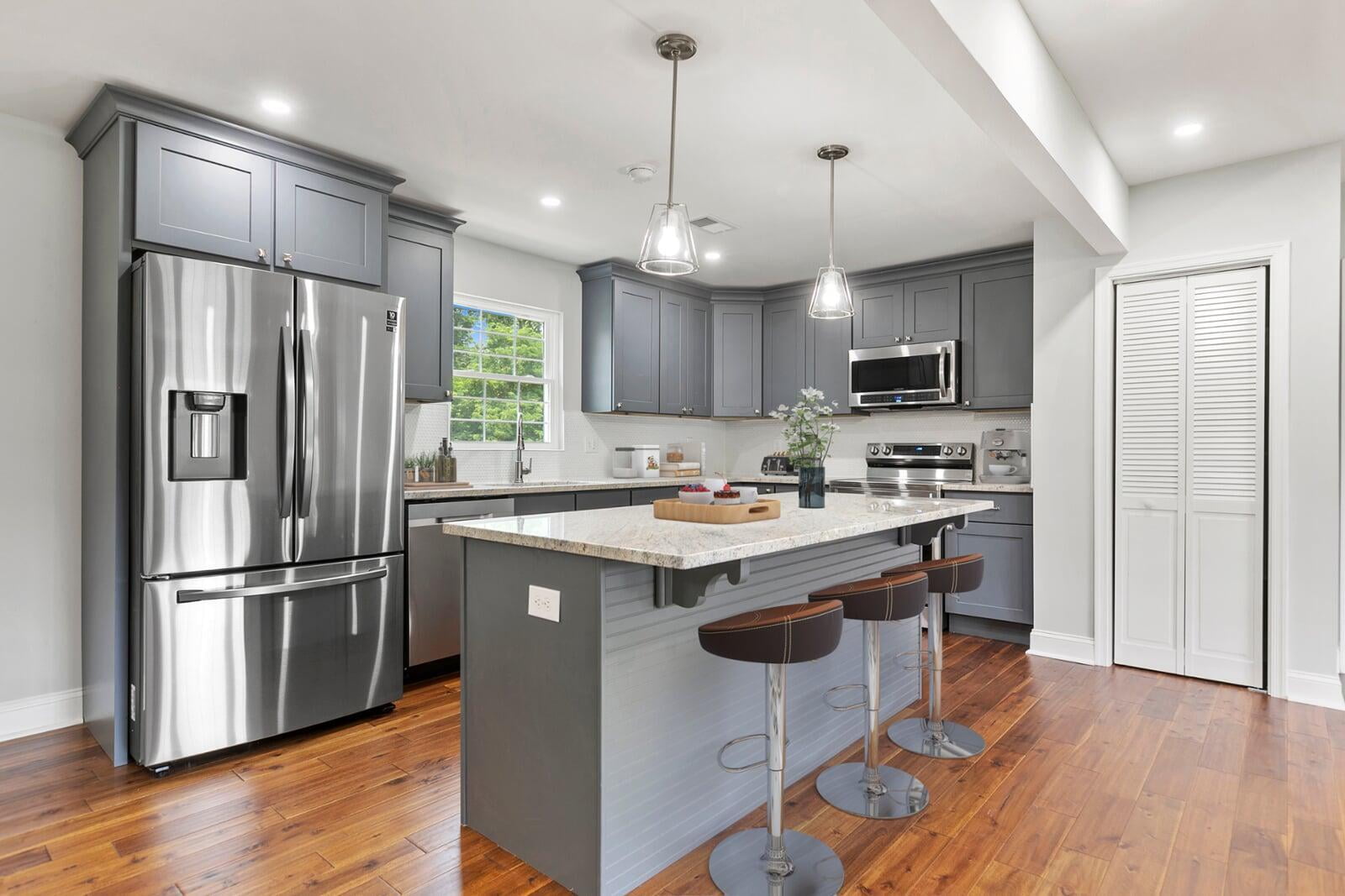 Project 07: kitchen with gray cabinetry, island seating, and wood floors